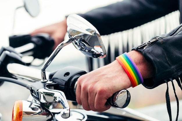 Nahaufnahme der Hände eines Mannes mit Regenbogenarmband