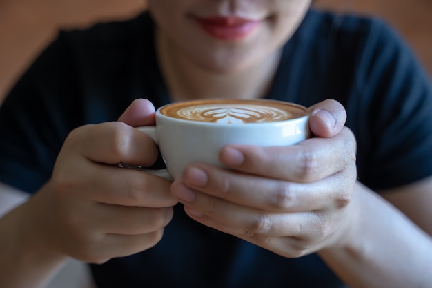 Nahaufnahme der Hände Junge Frau hält eine Tasse Kaffee in einem Café