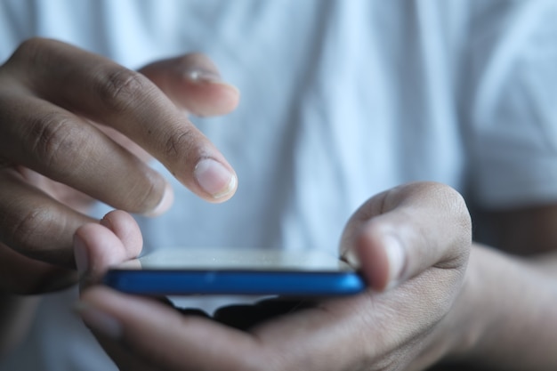 Nahaufnahme der Hand des jungen Mannes mit Smartphone