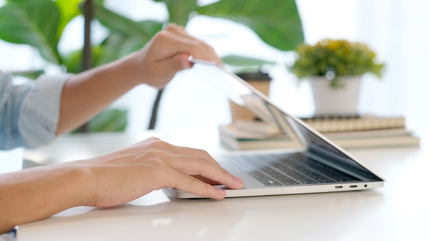 Nahaufnahme der Hand des Mannes, die Laptop während der Arbeit im Homeoffice öffnet, Online-Studium der Studentenhochschule, Lernen, Menschen und Technologie