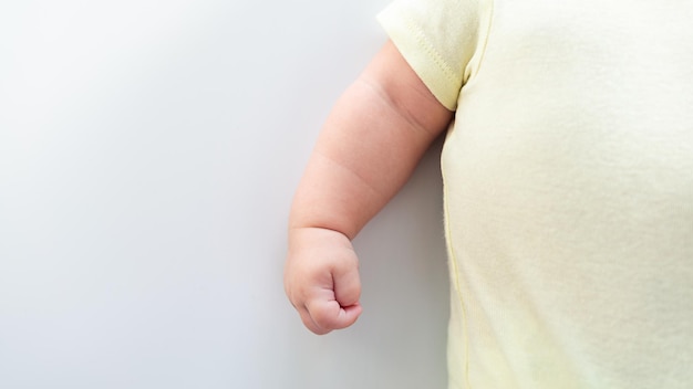 Nahaufnahme der Hand des neugeborenen Jungen auf weißem Blatthintergrund Baby schläft auf dem Bett