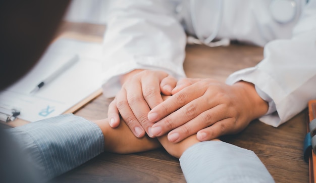 Foto nahaufnahme der hand des psychiaters, die die hand des patienten hält. den patienten ermutigen und trösten