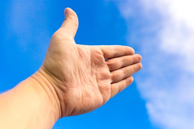 Nahaufnahme der Hand einer Person gegen den blauen Himmel