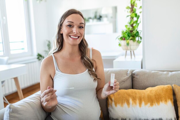 Nahaufnahme der Hand einer schwangeren Frau, die ein negatives Testgerät hält. Glückliche schwangere Frau, die ihren negativen Coronavirus - Covid-19-Schnelltest zeigt. Coronavirus