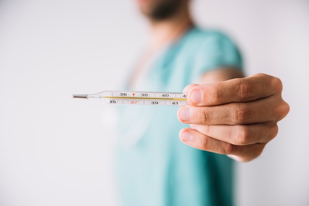 Foto nahaufnahme der hand eines doktors, die thermometer zeigt