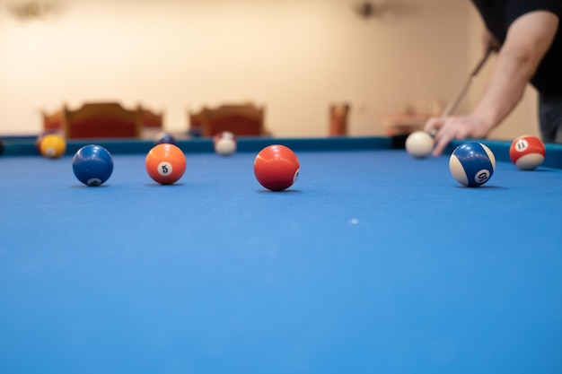 Nahaufnahme der Hand eines Mannes auf einem Billardtisch, der Snooker spielt und sich darauf vorbereitet, Billardkugeln zu schießen