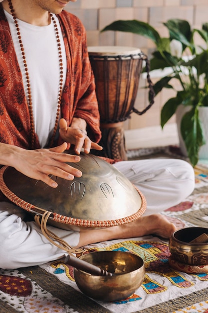 Foto nahaufnahme der hand eines mannes, der ein modernes musikinstrument spielt, die orion-schilftrommel