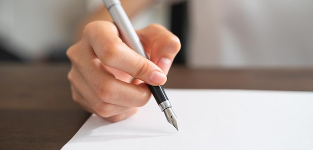 Nahaufnahme der Hand hält Stift und unterzeichnet Vertragsunterlagen im Büro