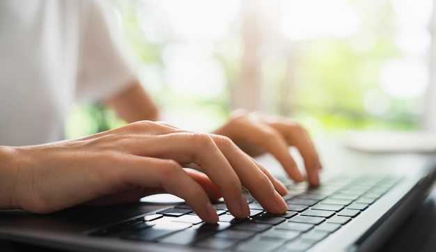 Foto nahaufnahme der hand mit computer und tastatur, die online ins internet tippen.