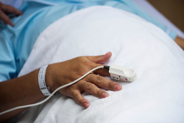 Nahaufnahme der Hand mit Fingerpulsoximeter