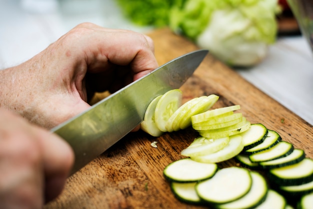 Nahaufnahme der Hand mit Messerschneidegurke