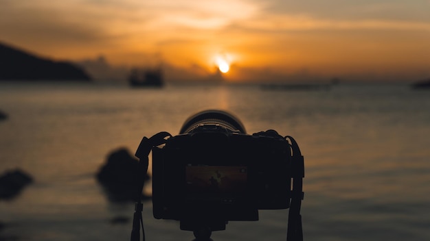 Foto nahaufnahme der kamera am strand gegen den himmel bei sonnenuntergang