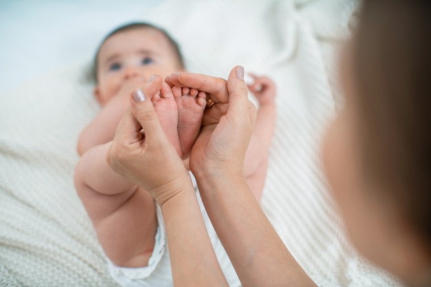 Nahaufnahme der Kinderfußmassage auf dem Bett.