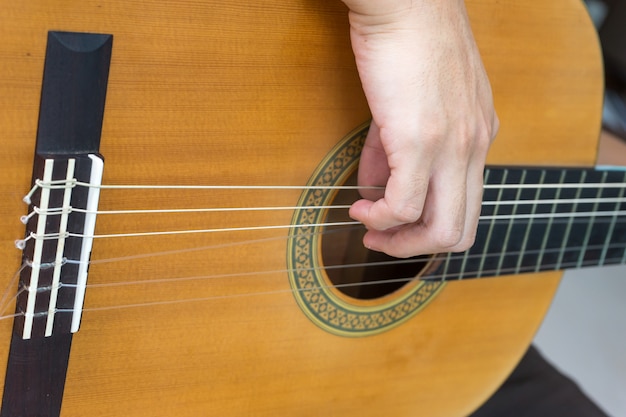 Nahaufnahme der klassischen Gitarrensaiten mit den Fingern