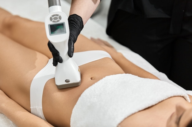 Nahaufnahme der Masseur-Dong-Massage auf weiblichem Bauch durch LPG-Gerät