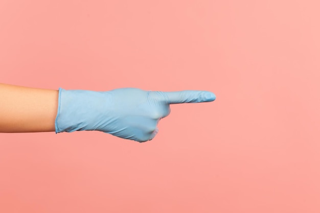Nahaufnahme der menschlichen Hand in blauen OP-Handschuhen, die mit dem Finger auf etwas zeigen oder zeigen.