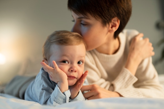 Nahaufnahme der Mutter, die den Kopf des Babys küsst