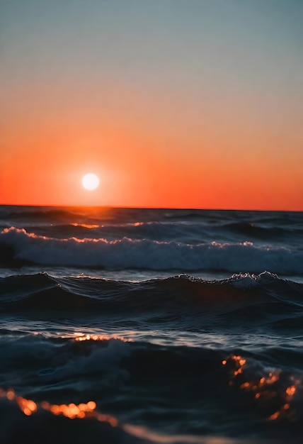 Nahaufnahme der Ozeanwellen beim Sonnenuntergang mit der Sonne am Horizont und einem orangefarbenen Himmel