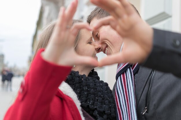 Nahaufnahme der Paare, die Herzform mit den Händen machen. Winterzeit. Valentinsgruß-Paar. Liebe Konzept. Herzzeichen.