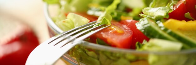 Nahaufnahme der Platte mit Grüns und Tomatensalat und -gabel. Gesunder Lebensstil gesundes Lebensmittelkonzept