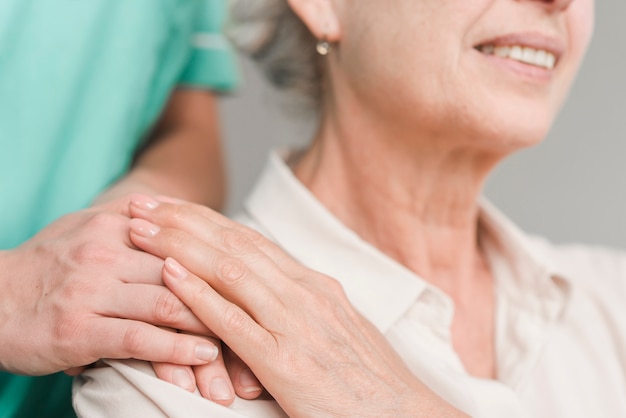 Foto nahaufnahme der rührenden krankenschwesterhand der älteren frau