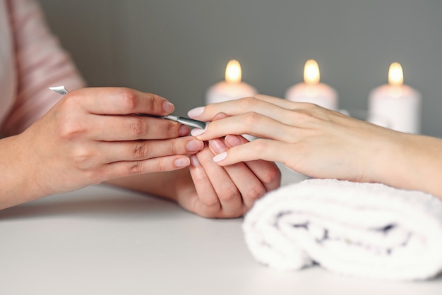Nahaufnahme der schönen Frauenhände, die Maniküre im Spa-Salon erhalten