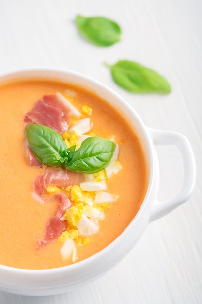 Nahaufnahme der spanischen Salmorejo-Suppe aus pürierten Tomaten und Brot mit Basilikumblatt dekoriert?