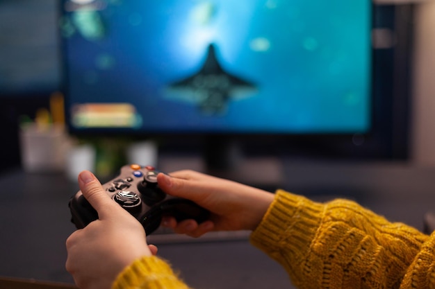 Nahaufnahme der Spielerhand, die Gaming-Joystick hält und Space-Shooter-Videospiele während der Online-Meisterschaft zu Hause im Wohnzimmer spielt. Gamer-Streaming-Videospiel. Späte Meisterschaft