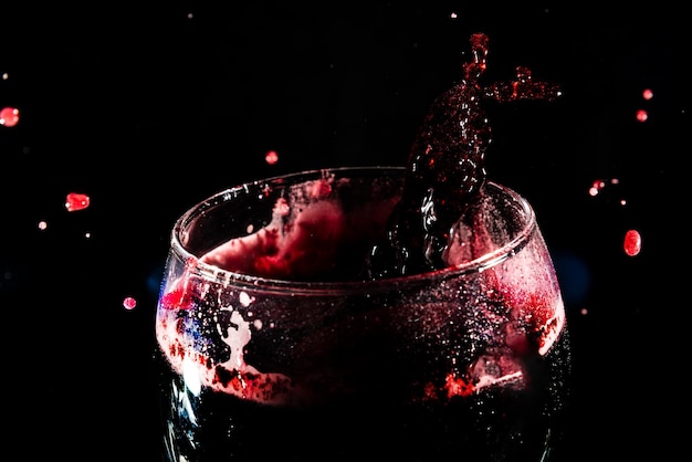 Foto nahaufnahme der spitze eines durchsichtigen glasbechers, der mit wein gefüllt ist, mit wasserspritzen splash-effekt