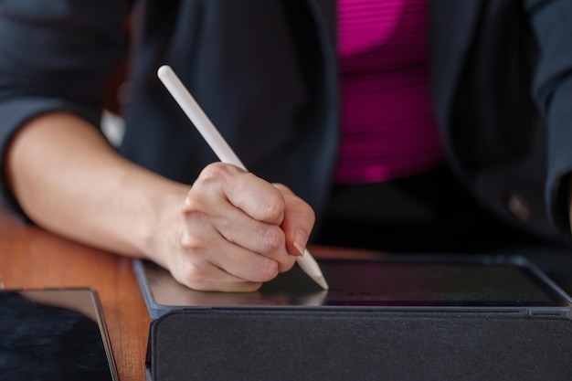 Nahaufnahme der studentenhand hält einen stift, der auf tabletconcept für college-prüfung schreibt