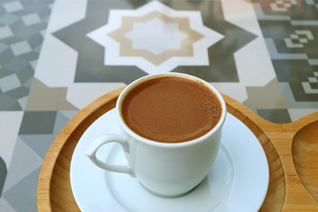 Nahaufnahme der Textur des türkischen Kaffees, der auf einem Steintisch mit maurischem Muster serviert wird