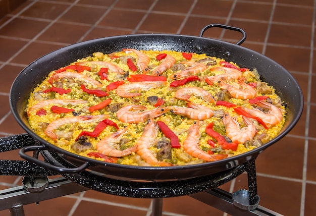 Nahaufnahme der traditionellen spanischen Paella in einer Pfanne gekocht, mit gelbem Reis und Meeresfrüchten