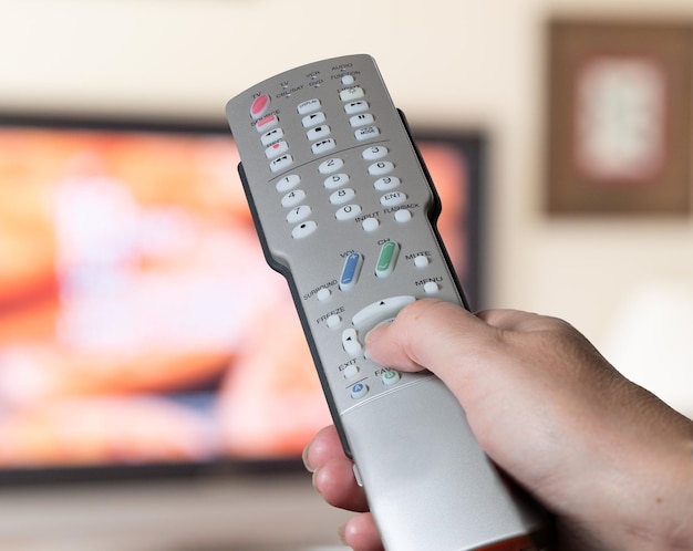 Nahaufnahme der TV-Fernbedienung mit Fernseher