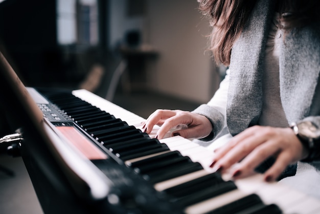Nahaufnahme der unerkennbaren weiblichen Person, die Klavier spielt.
