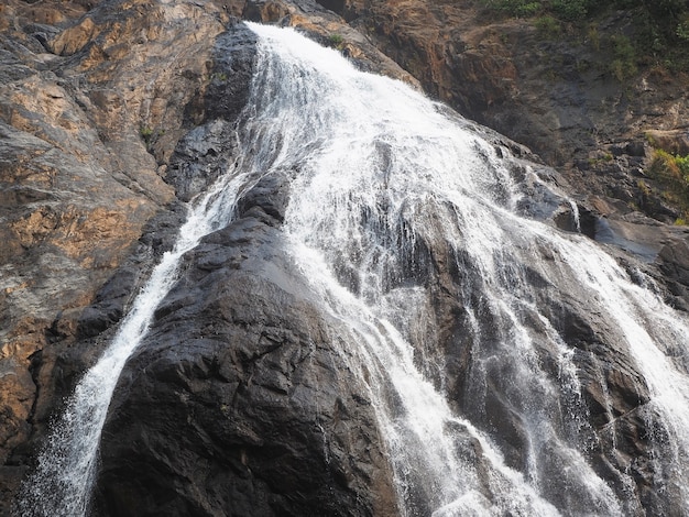 Nahaufnahme der wasserfallbewegung im park. der wasserstrahl umfließt den felsen und fällt herunter