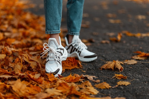 Nahaufnahme der weiblichen Beine in der stilvollen blauen Jeans in den trendigen Schuhen