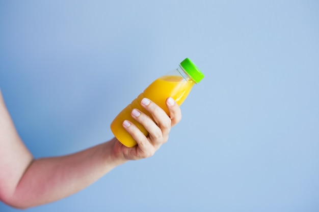 Nahaufnahme der weiblichen Hand, die eine Flasche mit Saft hält