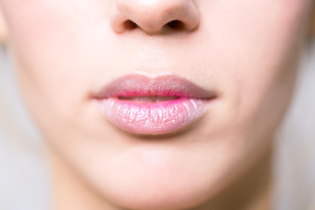 Nahaufnahme der weiblichen Lippen Rosa leuchtender Lippenstift auf den Lippen