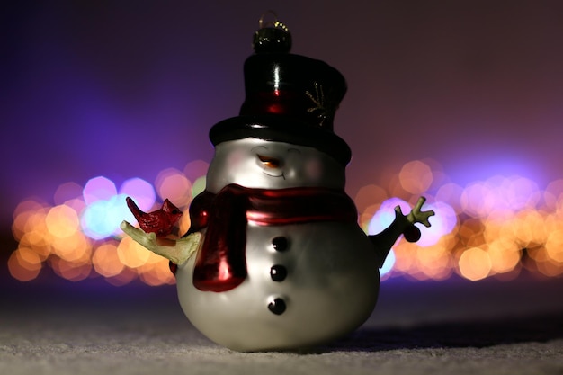 Foto nahaufnahme der weihnachtsdekoration des schneemannes gegen beleuchtete lichter