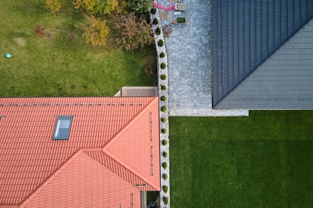 Nahaufnahme des Dachfensters auf dem Dach des Hauses, das mit Keramikschindeln bedeckt ist Gekachelte Abdeckung des Gebäudes