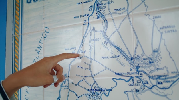 Foto nahaufnahme des fingers, der auf die karte zeigt und in die richtung der verlorenen touristischen planungsroute blickt
