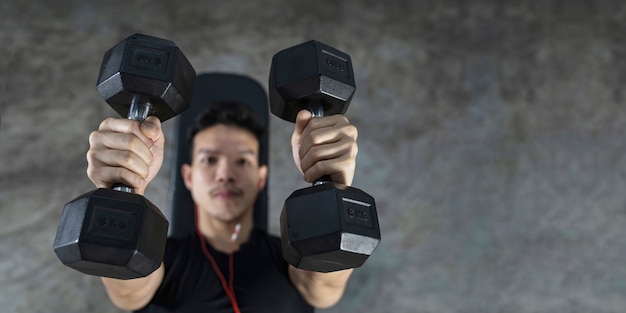 Nahaufnahme des Fitnessmannes, hübsches athletisches Kerltraining mit Hanteln