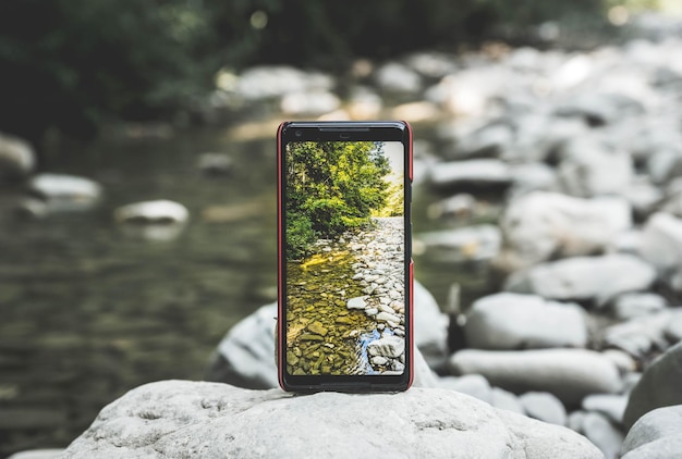 Nahaufnahme des Flusses durch Mobiltelefon auf verschwommenem Hintergrund