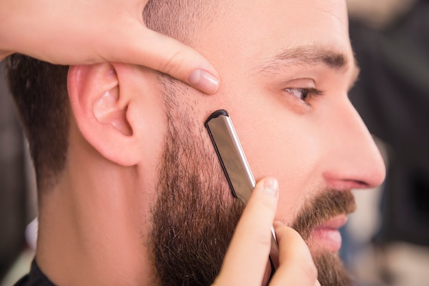 Nahaufnahme des Friseurs ein altmodisches Rasiermesser rasierend.