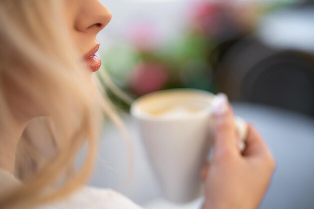 Foto nahaufnahme des gesichts eines schönen mädchens, das kaffee trinkt