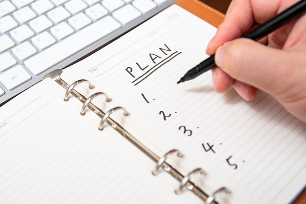 Nahaufnahme des Handschriftplans und -liste eines Geschäftsmannes im Tagebuch.