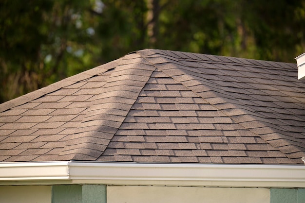 Nahaufnahme des Hausdaches mit Asphalt- oder Bitumenschindeln bedeckt Abdichtung des Neubaus