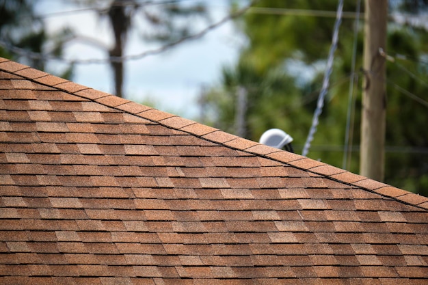 Nahaufnahme des Hausdaches mit Asphalt- oder Bitumenschindeln bedeckt Abdichtung des Neubaus