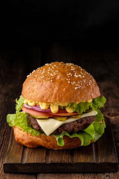 Nahaufnahme des hausgemachten leckeren Hamburgers auf Holztisch.