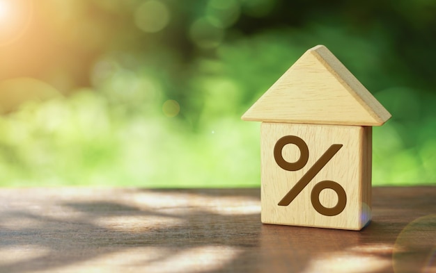 Nahaufnahme des Hausmodells und des Holzblocks mit dem Prozentsatz Immobilieninvestitionsimmobilien